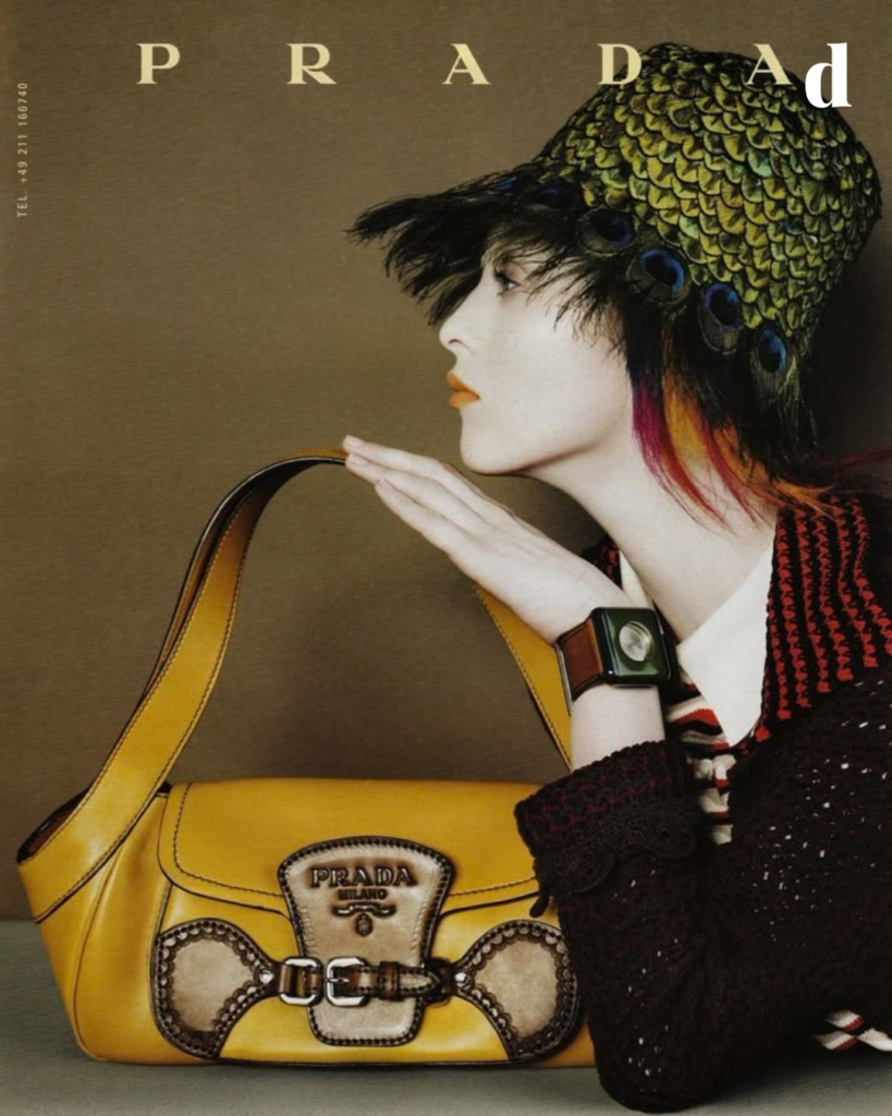 Prada's history from its 1913 Milan origins to Miuccia Prada, Raf Simons, nylon, Miu Miu, Versace, cultural influence and Spring 2027.